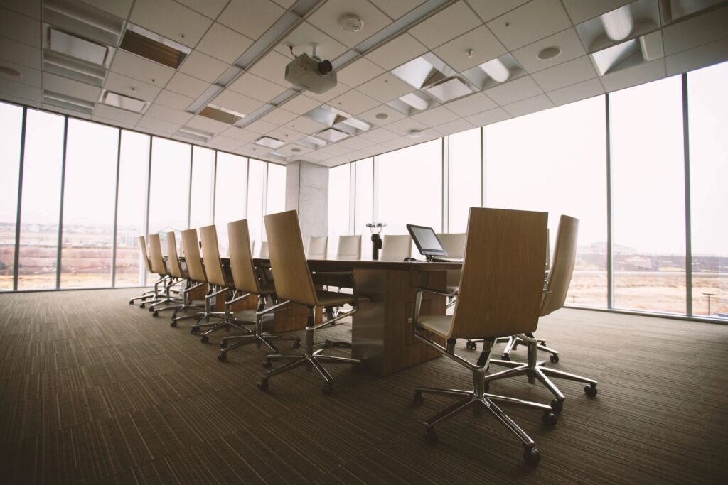 Image of a board room with rolling chairs around a table